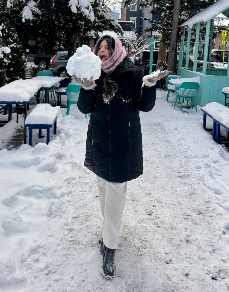 Jagriti holding a snowball in the snow